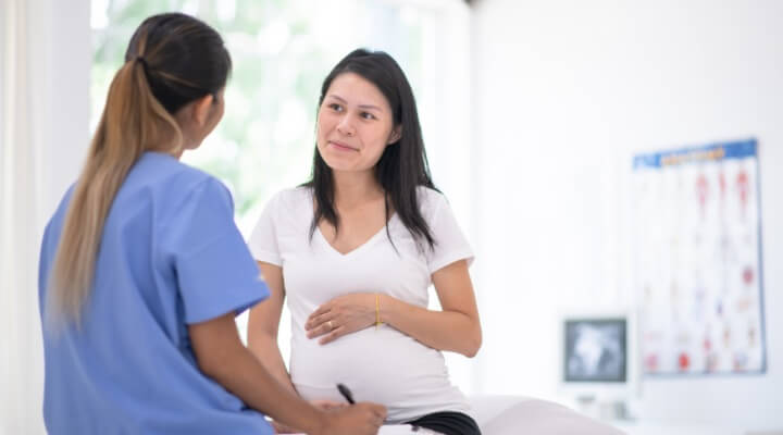 pregnant woman talking to dermatologist